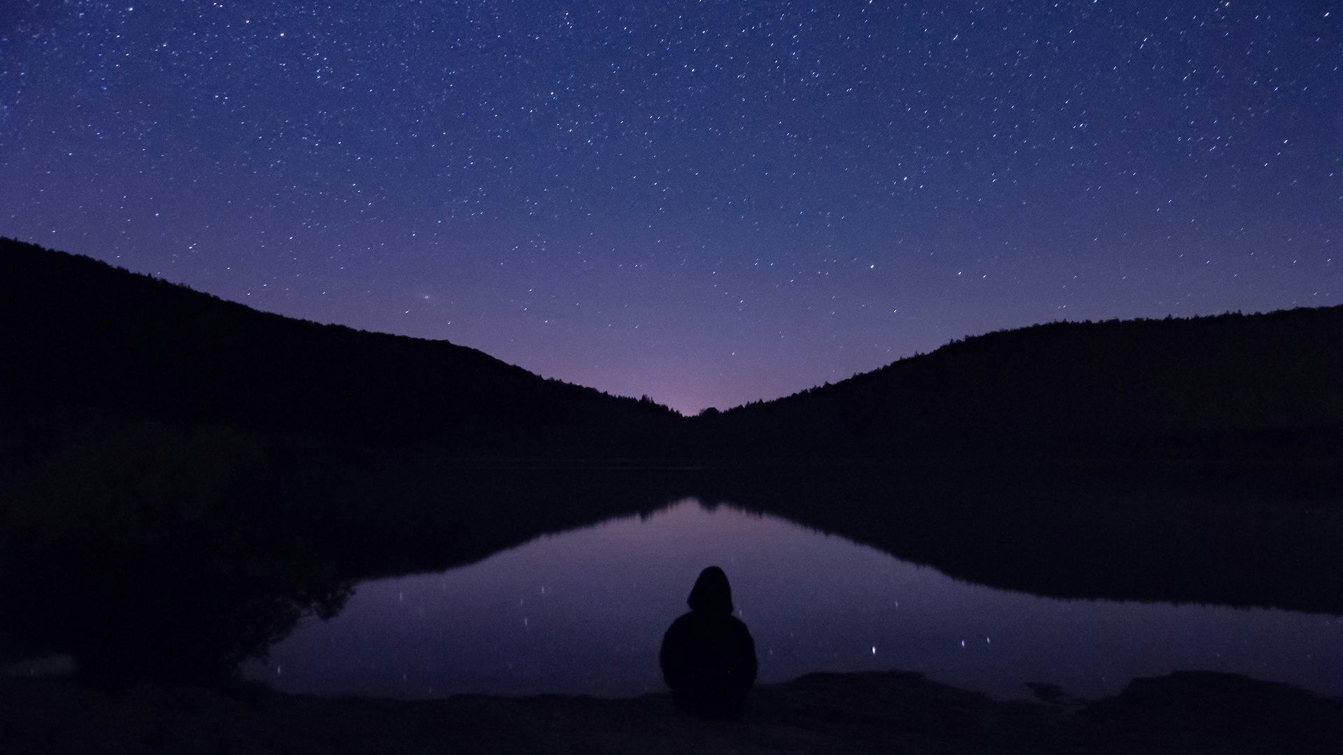 Peaceful night sky by a calm lake symbolizing comfort and reassurance